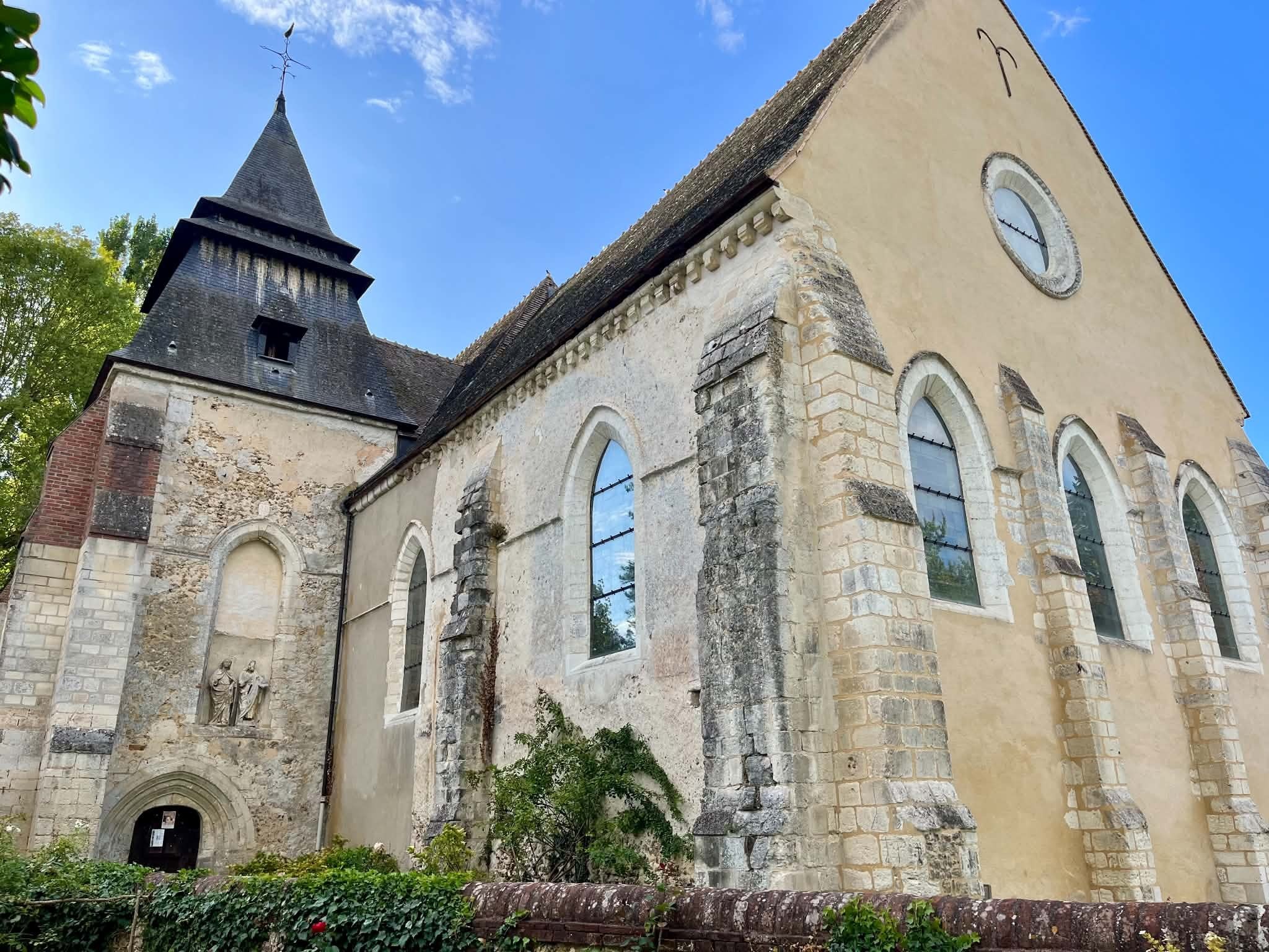 L’église Saint-Jean-Baptiste de Muzy vue du sud-est : la nef romane, les baies en plein cintre et le clocher couvert d’ardoise
